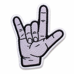 May include: An embroidered patch in the shape of a hand making the I love you sign in American Sign Language. The hand is light purple with black embroidered outlines and details, featuring a white border around the entire edge of the patch.