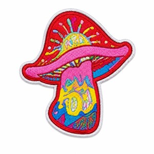 Puede incluir: Un parche bordado con forma de seta con un diseño vibrante y multicolor. El sombrero es rojo con un borde rosa y un patrón de rayos de sol amarillos, mientras que el tallo presenta patrones abstractos en espiral de colores azul, amarillo y rosa.
