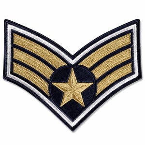 May include: A chevron-shaped embroidered patch featuring three horizontal gold stripes on a dark blue background. A gold five-pointed star is centered within a dark blue circle at the base of the chevron, framed by thin white and dark blue borders.