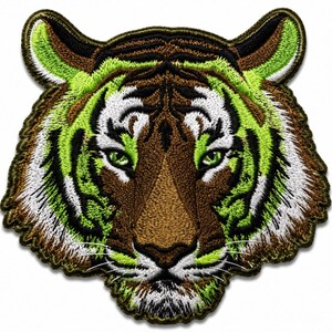 Puede incluir: Un parche bordado que presenta la cabeza de un tigre. El diseño incorpora hilos de colores verde lima vibrante, marrón oscuro, negro y blanco. El tigre se muestra de frente con costuras detalladas que definen sus rasgos faciales.