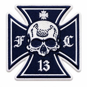 May include: A dark navy blue embroidered patch in the shape of a cross. The center features a white skull graphic with a small cross above it. The letters F and C are on the left and right arms, and the number 13 is at the bottom in white.