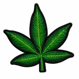 Puede incluir: Un parche bordado con forma de hoja de siete puntas. La hoja presenta tonos verdes vibrantes con costuras detalladas que representan las venas y la textura, todo ello delineado por un borde negro grueso y sólido sobre fondo blanco.
