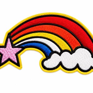 May include: An embroidered patch featuring a pink five-pointed star connected to a multi-coloured rainbow arching towards a white cloud. The design includes red, orange, yellow, and blue bands, all outlined in thick black and yellow thread borders.