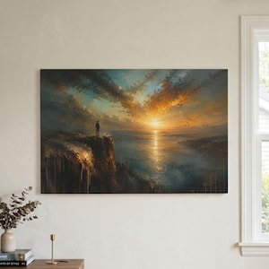 Op de afbeelding: Een rechthoekige wandkunstprint met een eenzame silhouet op een ruige klif die uitkijkt over een uitgestrekte oceaan bij zonsondergang. De lucht is gevuld met dramatische gouden, oranje en diepblauwe wolken, met licht dat reflecteert op het water.