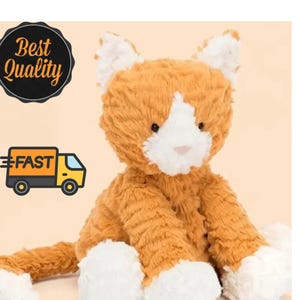 May include: A plush cat toy with orange and white fur. The cat has a white muzzle, white inner ears, and white paws. It features dark eyes and a small pink nose. The texture of the fur is soft and shaggy, giving the stuffed animal a fluffy appearance.