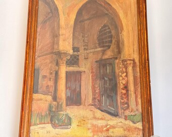 以下が含まれることがあります： 金色の木製フレームに入った油絵で、石のアーチ、柱、暗い木製のドアがある建築風景が描かれています。作品全体にオークル、ブラウン、タンの温かみのあるアースカラーが使われており、筆致がはっきりと見て取れます。