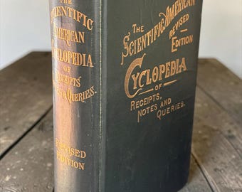 以下が含まれることがあります： Munn & Co.が出版した「The Scientific American Cyclopedia of Receipts, Notes and Queries, Revised Edition」というタイトルの黒いハードカバー本。表紙と背表紙には金色のエンボス文字が施されており、端には摩耗の跡が見られます。