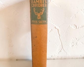 May include: A vintage hardcover book titled Bambi's Children by Felix Salten with a tan spine. The spine features a green rectangular inset with a deer head illustration, the title, the author's name, and the publisher Grosset & Dunlap at the base.