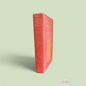 May include: A red hardcover book titled Courageous Companions by Charles J. Finger. The spine features gold embossed text and illustrations, including a dolphin and a ship. The front cover also displays gold lettering and a large decorative design.