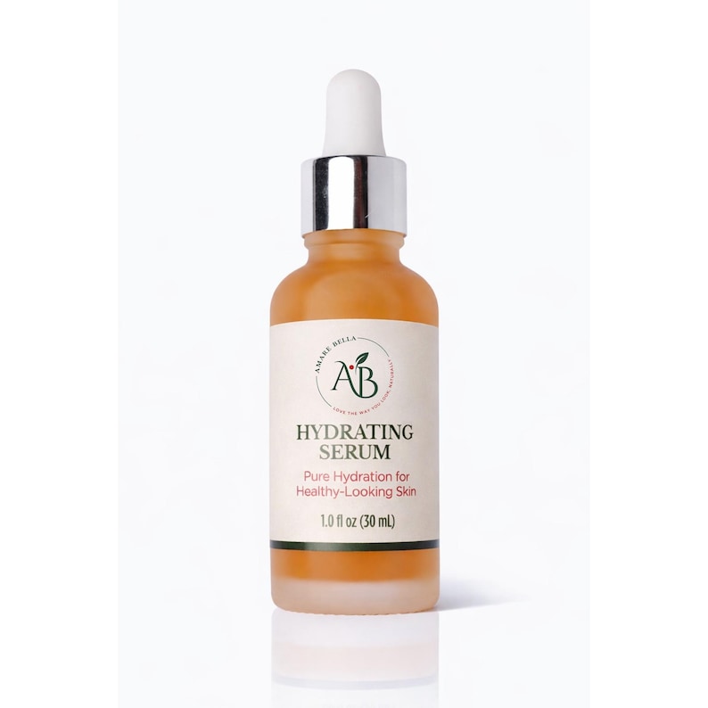 May include: A glass dropper bottle containing an amber-colored hydrating serum. The white label features the text Amare Bella AB, Hydrating Serum, Pure Hydration for Healthy-Looking Skin, and 1.0 fl oz (30 mL) with a silver collar and white dropper top.