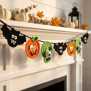 May include: A Halloween-themed crochet garland featuring alternating black bats, orange pumpkins with green stems, and green monster faces with single white eyeballs. The figures are connected by a black yarn string, creating a festive decoration.