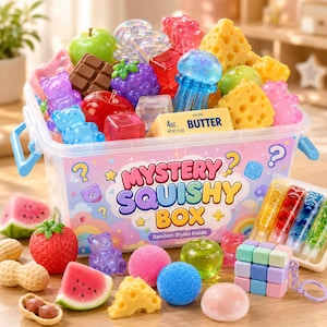 Può includere: Un contenitore in plastica trasparente etichettato Mystery Squishy Box contenente vari giocattoli morbidi a forma di frutta, formaggio, burro e animali. All'esterno si trovano altri oggetti morbidi, tra cui una fragola, una fetta di anguria, arachidi e un portachiavi a cubo.