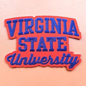 May include: An embroidered patch featuring the text Virginia State University in bold blue lettering against a bright orange background. The patch has a curved top edge and a scalloped bottom edge, with the word University in a script font.