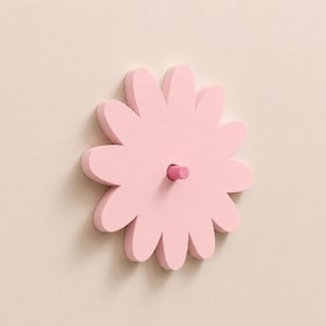 Può includere: Un gancio da parete rosa chiaro a forma di fiore con dodici petali arrotondati. Il centro del fiore presenta un piccolo piolo cilindrico rosa più scuro che sporge verso l'esterno, progettato per appendere oggetti alla parete.