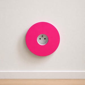 K&ouml;nnte beinhalten: Eine kreisf&ouml;rmige, leuchtend pinke Wandplatte mit einer mittig platzierten wei&szlig;en Steckdose. Das Design ist flach und geometrisch, mit einer glatten, einfarbigen Oberfl&auml;che, die die standardm&auml;&szlig;ige runde Steckdose in der Mitte umschlie&szlig;t.