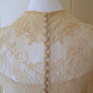 May include: A vintage ivory lace wedding dress with a button-up back.