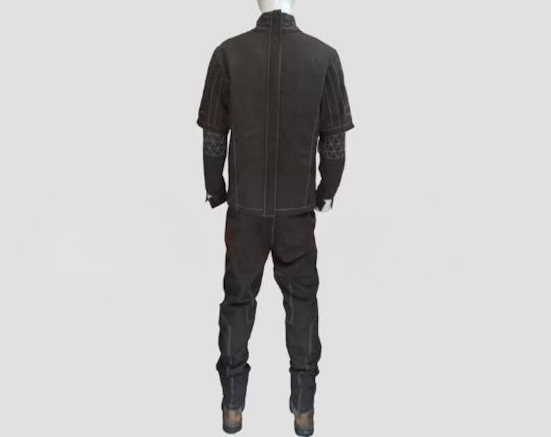 Peut inclure: Une combinaison noire dot&eacute;e d'un col montant, de manches courtes et d'un pantalon long. Le v&ecirc;tement pr&eacute;sente des coutures contrast&eacute;es blanches le long des lignes, un panneau central vertical dans le dos et des motifs triangulaires g&eacute;om&eacute;triques.