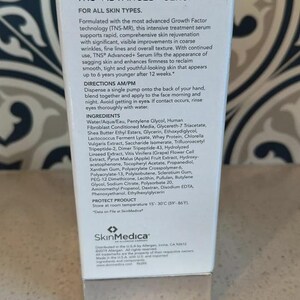 May include: A white rectangular box of SkinMedica TNS Advanced+ Serum. The front displays product information, directions, and a full list of ingredients. The text specifies storage at 15-30 degrees Celsius or 59-86 degrees Fahrenheit.