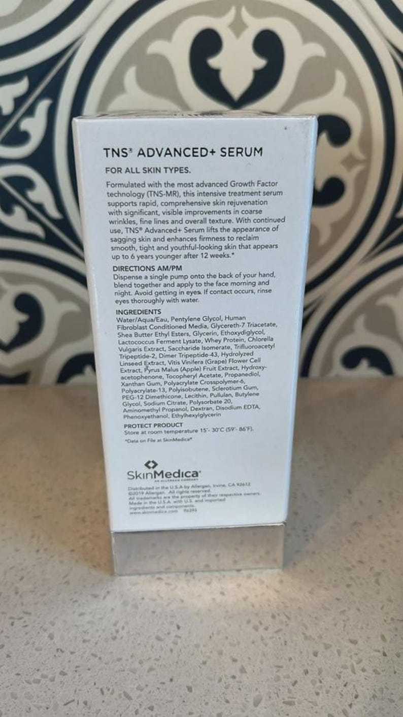 May include: A white rectangular box of SkinMedica TNS Advanced+ Serum. The front displays product information, directions, and a full list of ingredients. The text specifies storage at 15-30 degrees Celsius or 59-86 degrees Fahrenheit.