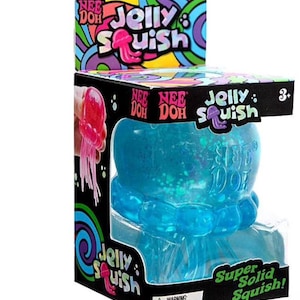 May include: A Nee Doh Jelly Squish toy in a black box with colorful swirl patterns. The box features the text Nee Doh Jelly Squish and Super Solid Squish. Inside is a translucent blue jellyfish-shaped squishy toy with glittery accents.