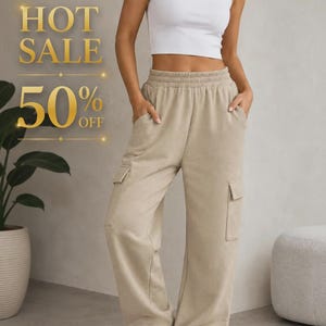 Puede incluir: Un top corto sin mangas blanco combinado con pantalones cargo de chándal beige de cintura alta con cintura elástica, bolsillos laterales y dos bolsillos cargo en las piernas. La imagen incluye el texto dorado HOT SALE 50% OFF.