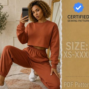 Könnte beinhalten: Ein rostfarbenes zweiteiliges Lounge-Set bestehend aus einem langärmeligen bauchfreien Sweatshirt und einer passenden hoch taillierten Jogginghose mit elastischen Bündchen. Der Text rechts lautet CERTIFIED SEWING PATTERN, SIZE: XS-XXXL, PDF Pattern.
