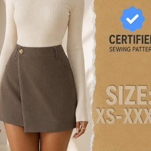 Puede incluir: Una falda pantalón gris oscuro con frente cruzado, un botón dorado en la cintura y bolsillos laterales. La imagen incluye el texto CERTIFIED SEWING PATTERN y SIZE: XS-XXXL con un icono de marca de verificación azul sobre fondo beige.