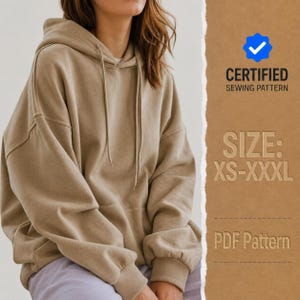 Puede incluir: Una sudadera con capucha de color beige con mangas largas, puños acanalados y un bolsillo delantero. La imagen incluye el texto: CERTIFIED SEWING PATTERN, SIZE: XS-XXXL y PDF Pattern. La sudadera tiene capucha con cordón y corte holgado.