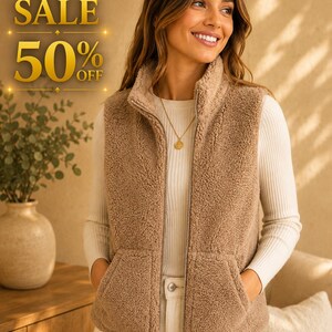Puede incluir: Un chaleco sin mangas de forro polar sherpa en color beige con cremallera frontal completa, cuello alto y dos bolsillos delanteros, sobre una camiseta blanca de manga larga acanalada. La imagen incluye el texto HOT SALE 50% OFF en letras doradas.