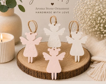 May include: Four angel-shaped aroma stone ornaments with jute twine loops. Two are pale pink, and two are white. The ornaments feature embossed star and heart patterns. Text on the image reads: Guardian Angel, Aroma Stone Ornament, HANDMADE WITH LOVE.