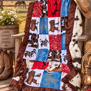 May include: A patchwork throw blanket featuring a western theme with squares of red paisley, brown cow print, blue denim texture, and illustrations of saddles and horses. The blanket has a brown satin border and a white faux fur backing.