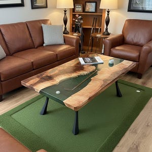 May include: A rectangular coffee table featuring a live-edge wood slab with a central green resin river inlay. Embedded within the resin are a golf club and a golf ball. The table is supported by four black metal legs and sits on a green rug.