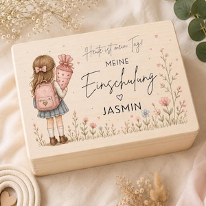 Könnte beinhalten: Eine rechteckige Holzbox mit einem aufgedruckten Bild eines Kindes mit Rucksack, das eine Schultüte hält, umgeben von Blumen. Der Text lautet: Heute ist mein Tag! MEINE Einschulung JASMIN. Das Design enthält kleine Herzen und florale Akzente.