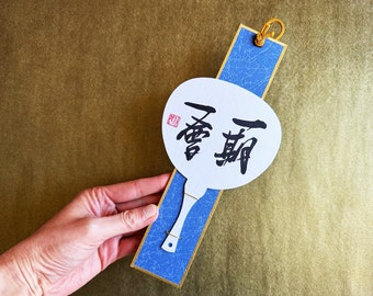 Ichigo Ichie 一期一会 - Calligraphie kanji japonaise sur tableau blanc en forme d'éventail japonais - Cadre bleu de style Kakejiku à suspendre