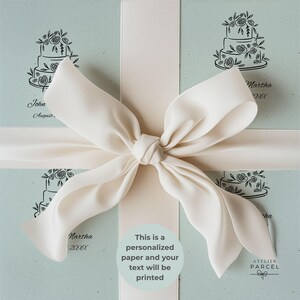 Könnte beinhalten: Ein helles salbeigrünes Geschenkpapier mit einer wiederkehrenden schwarzen Strichzeichnung einer dreistöckigen floralen Hochzeitstorte, akzentuiert durch eine große, mittig gebundene cremefarbene Satinschleife, mit aufgedrucktem Text.