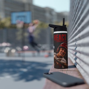 May include: A black water bottle with a black lid and straw, featuring the red text REACT above a graphic of a baseball player wearing a red helmet and swinging a bat. The bottle has a cylindrical shape and a smooth, matte finish surface.