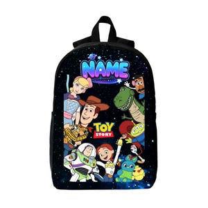 Op de afbeelding: Een zwarte rugzak met een achtergrond in ruimtethema met sterren en planeten. De voorkant toont het Toy Story-logo en personages zoals Woody, Buzz Lightyear, Jessie, Rex, Bo Peep en anderen. Het woord NAME staat bovenaan gedrukt.
