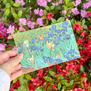 Può includere: Una cartolina rettangolare con un'illustrazione colorata di personaggi Pikachu gialli immersi tra vivaci fiori di iris blu e fogliame verde, resa in uno stile pittorico strutturato con pennellate visibili.