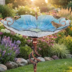 May include: A bird bath featuring a wide, scalloped glass bowl with blue and white radial patterns, supported by a copper-colored metal stand with a twisted design and decorative scroll accents, with two small birds perched on the rim.