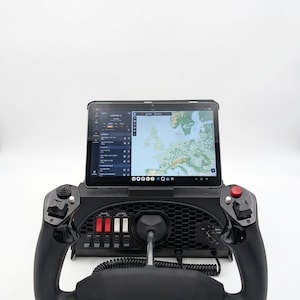 May include: A black flight simulator yoke with a central tablet mount displaying a digital map of Europe. The device features a honeycomb-patterned base, multiple toggle switches in red and white, a red button, and various control inputs.