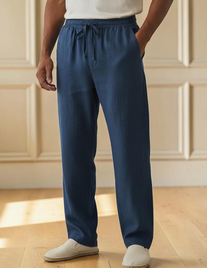 Peut inclure: Pantalon bleu marine uni dot&eacute; d'une taille &eacute;lastique avec un cordon de serrage assorti, de poches lat&eacute;rales et d'une coupe droite. Le pantalon est confectionn&eacute; dans un tissu textur&eacute; et est associ&eacute; &agrave; un haut blanc uni et des chaussures claires.
