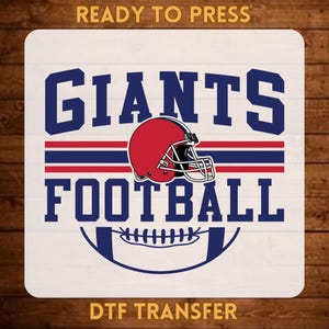 May include: A DTF transfer featuring the text READY TO PRESS at the top and DTF TRANSFER at the bottom. The center graphic displays the text GIANTS FOOTBALL in navy blue, a red football helmet, and a stylized football graphic with red and blue stripes.