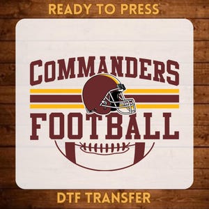 May include: A DTF transfer featuring the text READY TO PRESS at the top and DTF TRANSFER at the bottom. The center graphic displays a burgundy football helmet with a white facemask, surrounded by the text COMMANDERS FOOTBALL in burgundy.