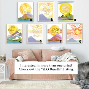 May include: Seven watercolor prints with a mountain and sun design. Each print features a different phrase, including "The Slo Life", "Slo Chill", "Slo Happy", "Slo Beautiful", "Slo Down", "Love Slo", and "Slo Down".