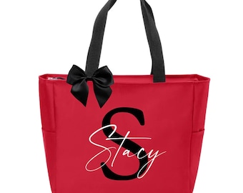 May include: Red canvas tote bag with black handles and a black bow. The bag has a large black letter "S" and the name "Stacy" written in white cursive.