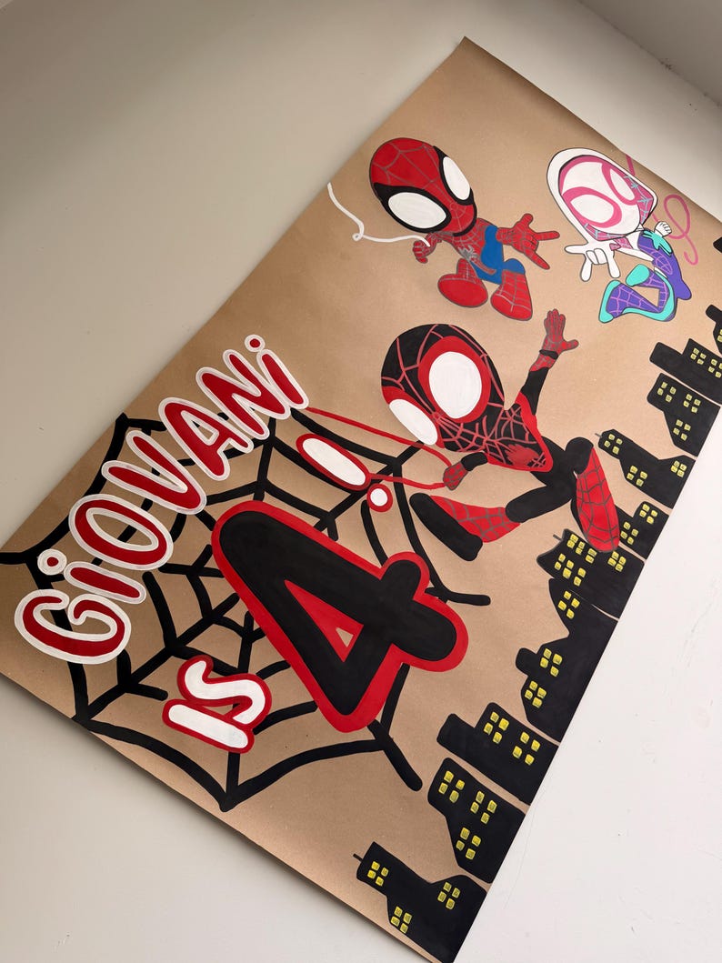 May include: A tan poster featuring hand-painted illustrations of three Spider-Man characters, a black spiderweb, and a black city skyline. The text reads "GIOVANI IS 4" in large red and black lettering, with the number 4 prominently displayed.