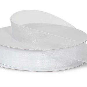 May include: A spool of white sheer ribbon with a shimmery finish. The ribbon is rolled up on a white cardboard spool.