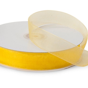 May include: A spool of yellow sheer ribbon. The ribbon is rolled up on a white cardboard core.
