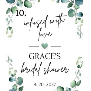 Puede incluir: Una invitaci&oacute;n blanca con eucalipto en acuarela y el texto "infused with love" y "Grace's bridal shower" con la fecha 20.09.2027. Un peque&ntilde;o coraz&oacute;n verde est&aacute; en el centro.