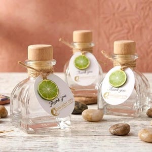 Botellas de tequila con recuerdo: botellas vacías de 50 ml con corcho, etiquetas personalizadas y dije de lima opcional.